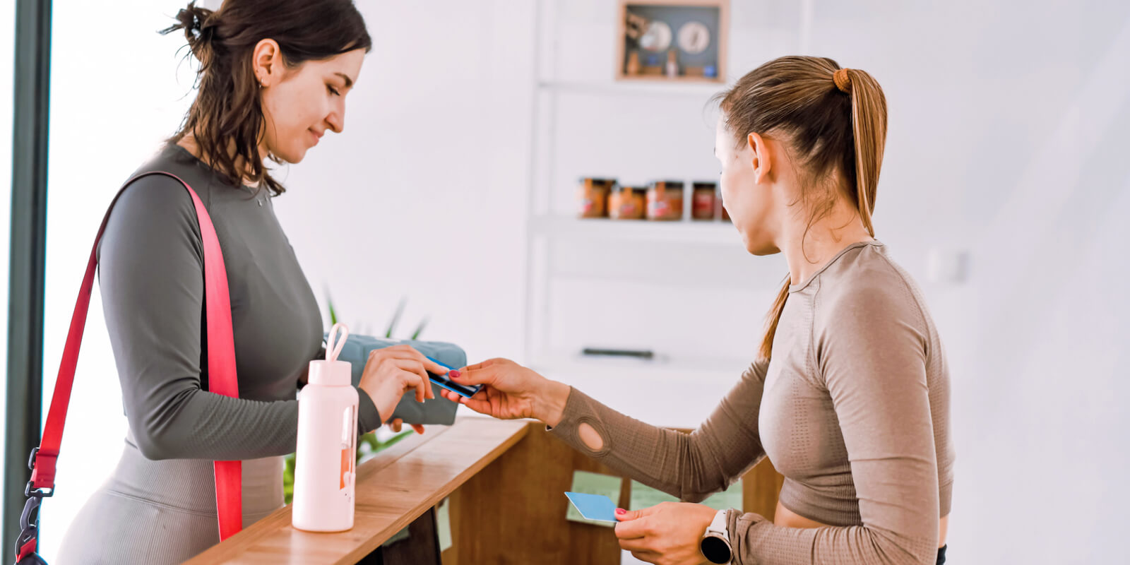 A customer at the front desk of a fitness studio purchasing a new membership with a joining fee via TeamUp.