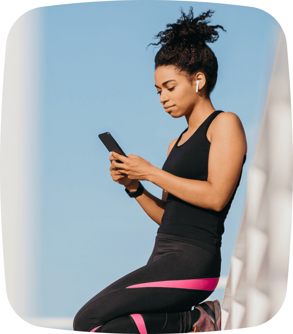 Woman using her mobile phone to book a Pilates class